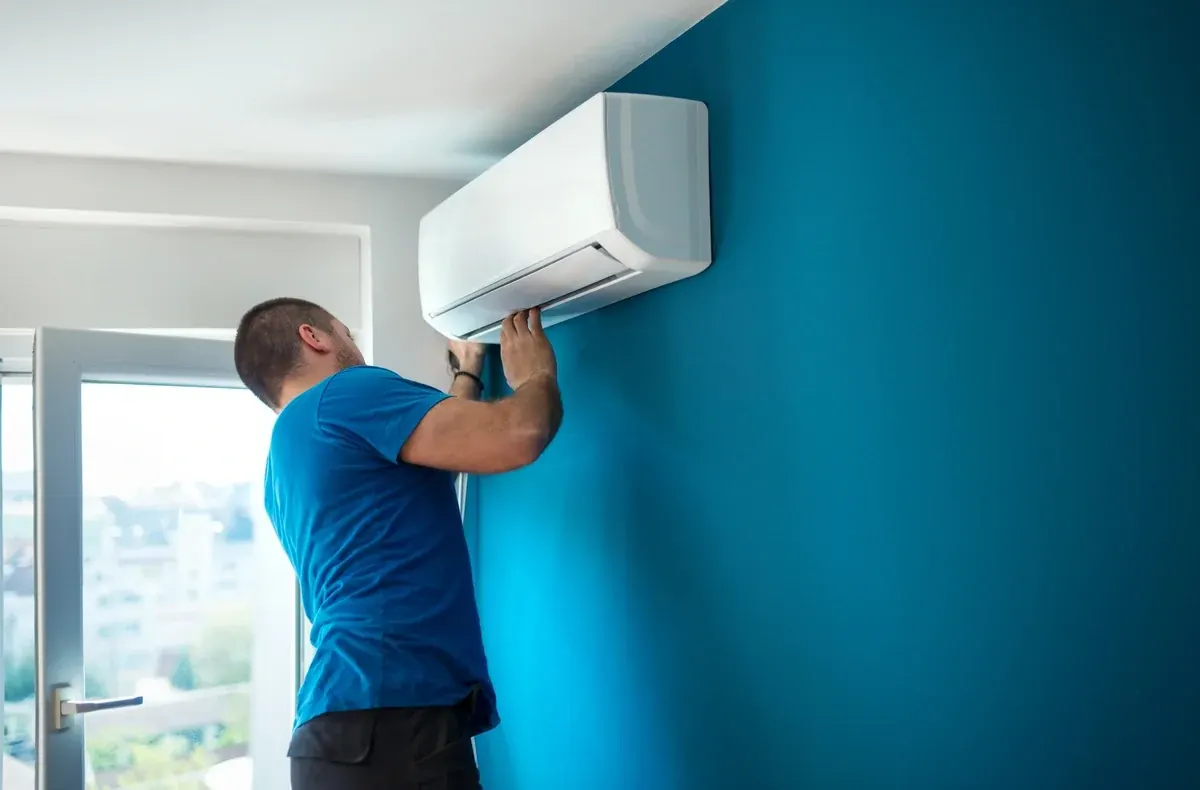 ATKINSONS engineer fitting a wall-mounted air conditioning unit