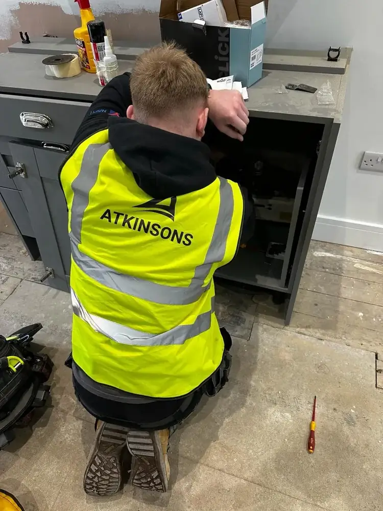 ATKINSONS fitter working in a customer's kitchen